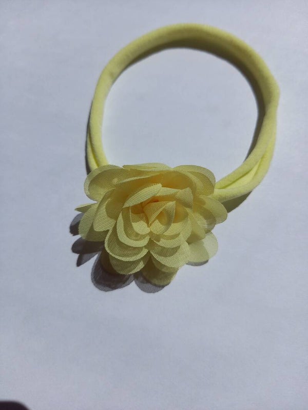 Een zacht kleur geel nylon haarbandje met bloem