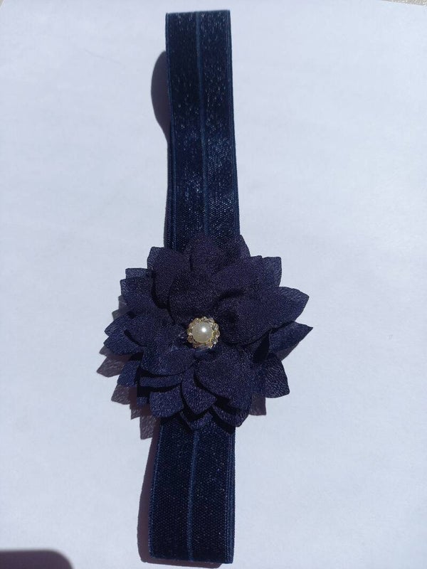 Een donkerblauw haarbandje met bloem