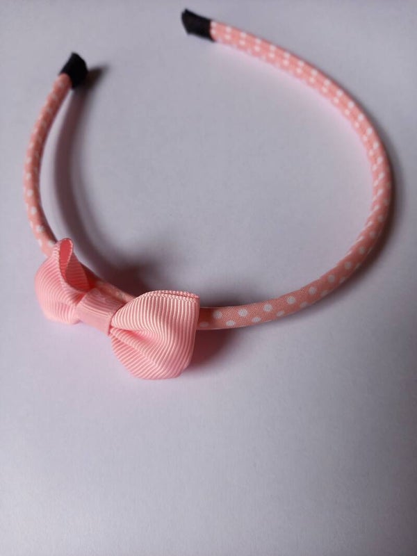 Een licht roze hard haarbandje met een wit stipje