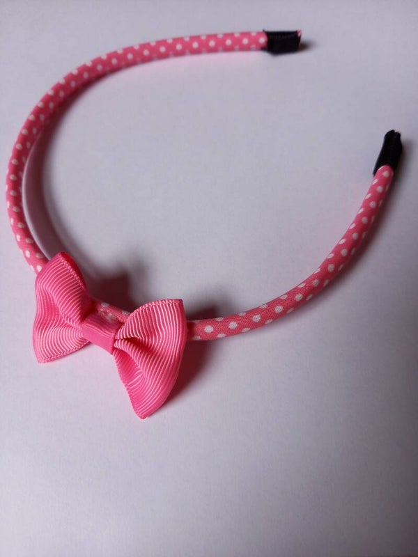 Een hard fuschia kleur haarbandje met een wit stipje