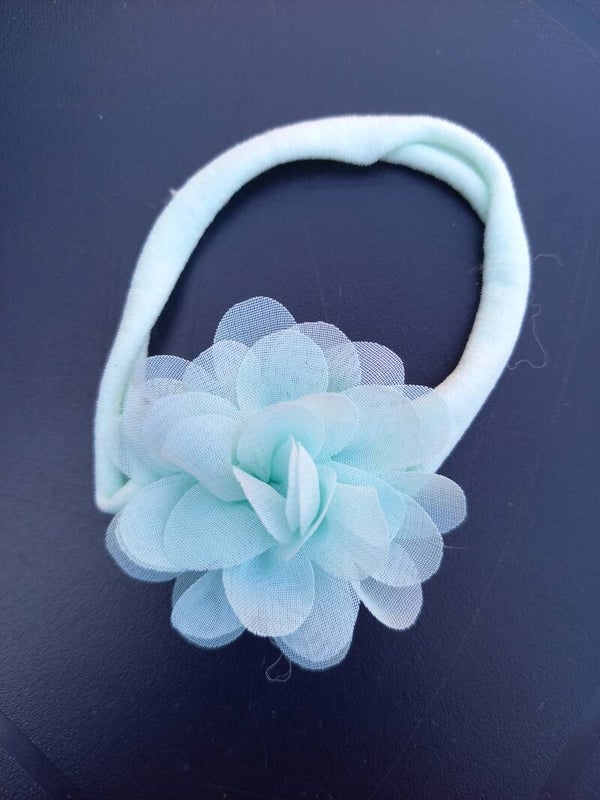 Een mint groen nylon haarbandje met bloem