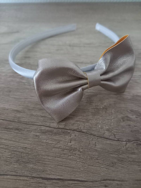 Witte harde haarband met een zilverkleurige strik