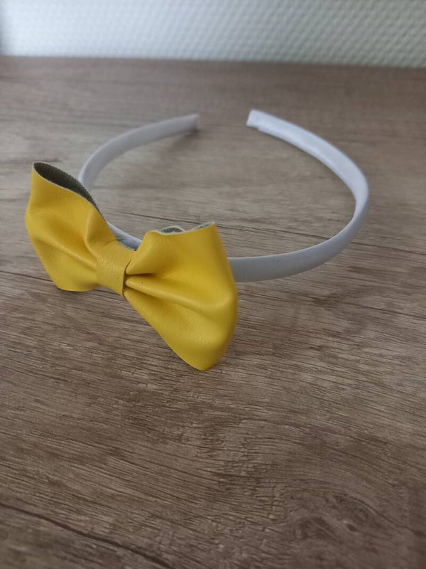 Witte harde haarband met een gele strik