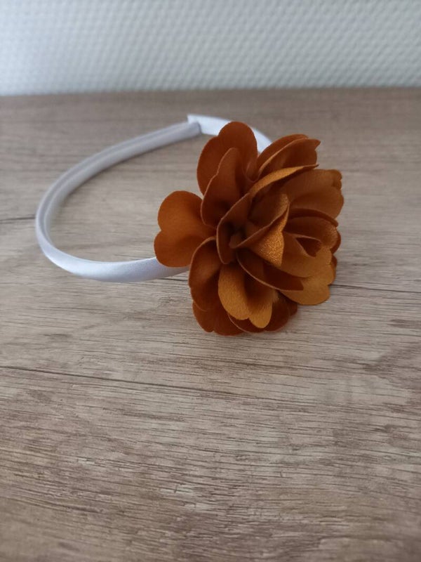 Wit hard haarbandje met een goud kleurige bloem