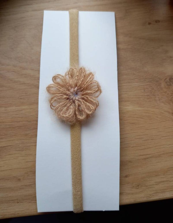 Taupe kleur nylon haarbandje met bloem