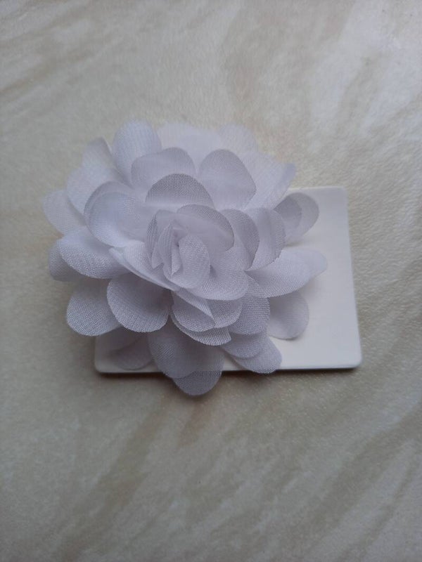 Een kleine witte bloem met haarschuifje