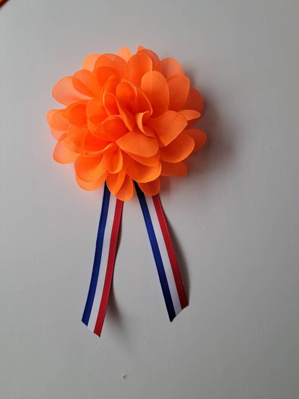 Grote bloem met rood,wit en blauw lint