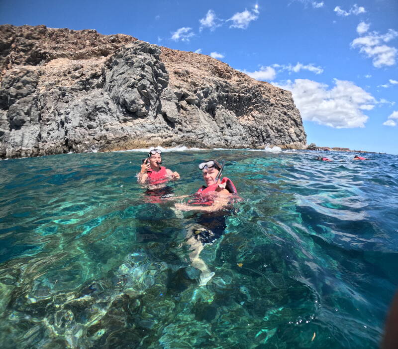 Couple of friends snorkeling in front of the pink cave of Palm Mar
