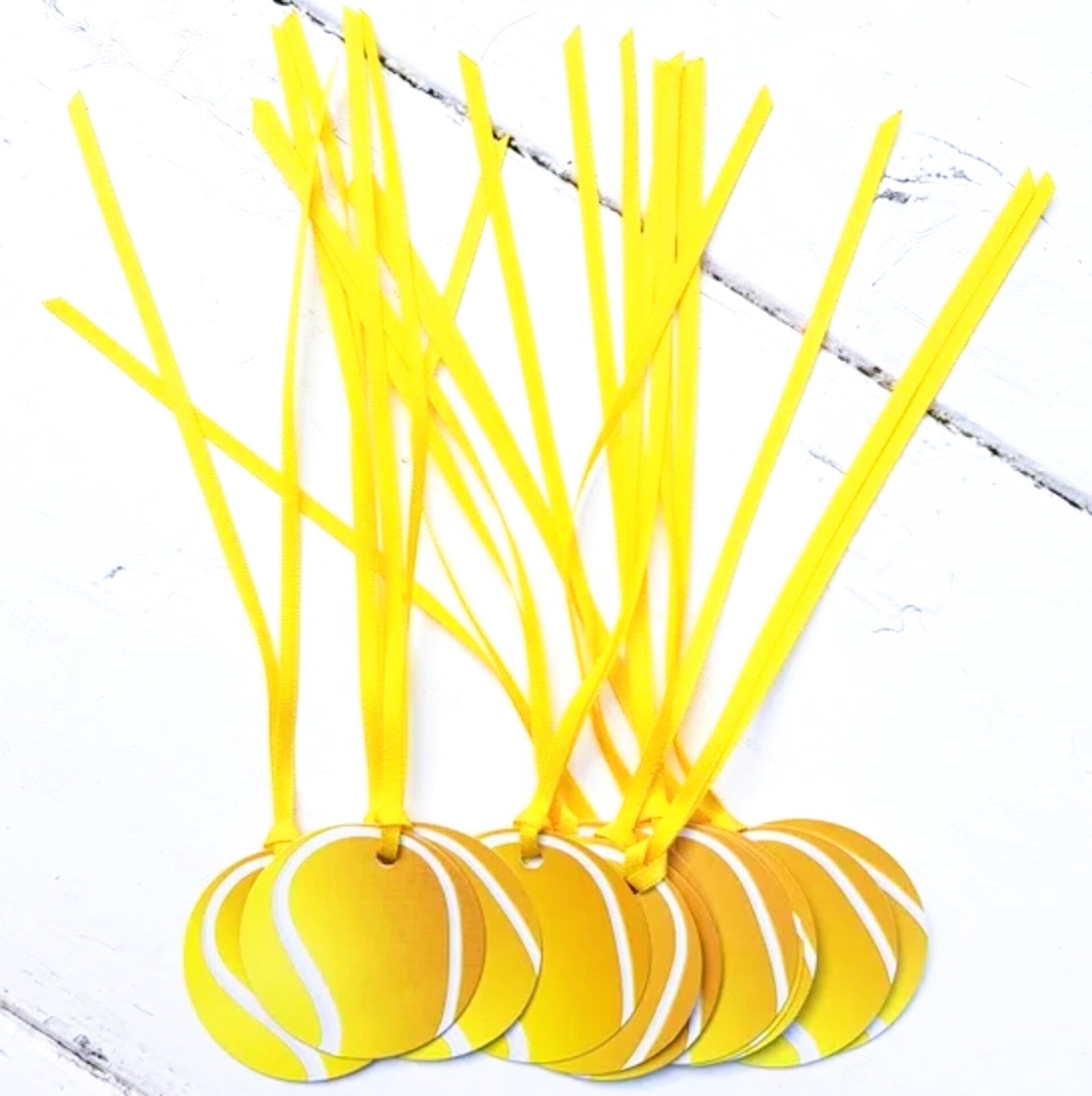 Pak met 12 kaartjes in de vorm van een tennisbal aan een lint