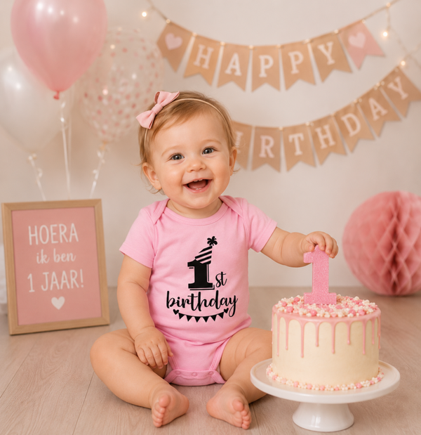 1e verjaardag romper It's my First Birthday roze met zwarte opdruk Maat: 12 maanden Met ronde hals, korte mouwen en druk knoopjes aan de onderkant