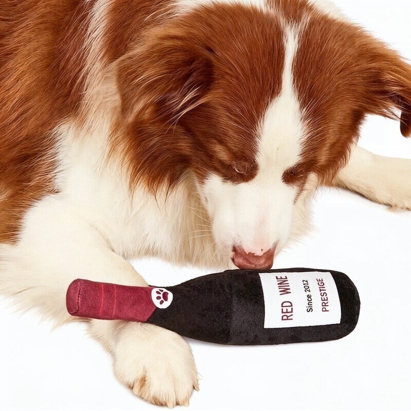 Pluche honden speeltje fles rode wijn