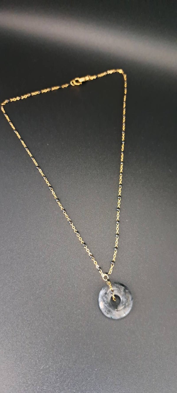 collier doré avec un disque en céramique noir