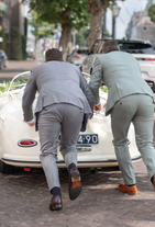 Bruidegom en broer duwen kapotte Porsche trouwauto terwijl bruid achter stuur zit , spontane trouwfoto.