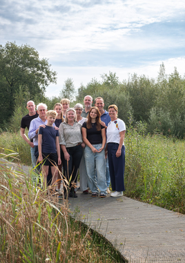 Gezin lacht samen tijdens ontspannen familieshoot – gezinsfotografie op locatie.