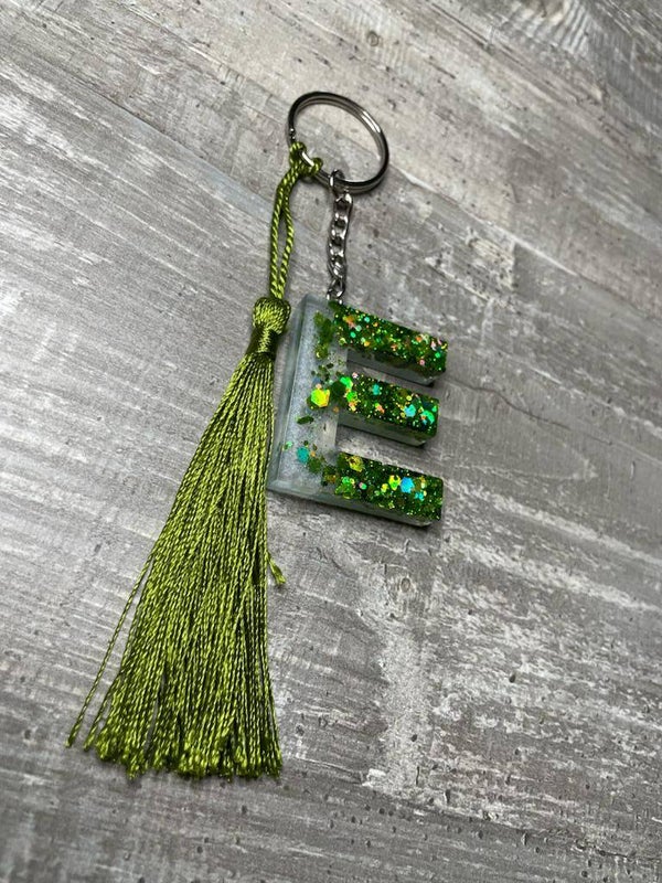 Porte clés Lettre "E" fond blanc et paillettes vert militaire