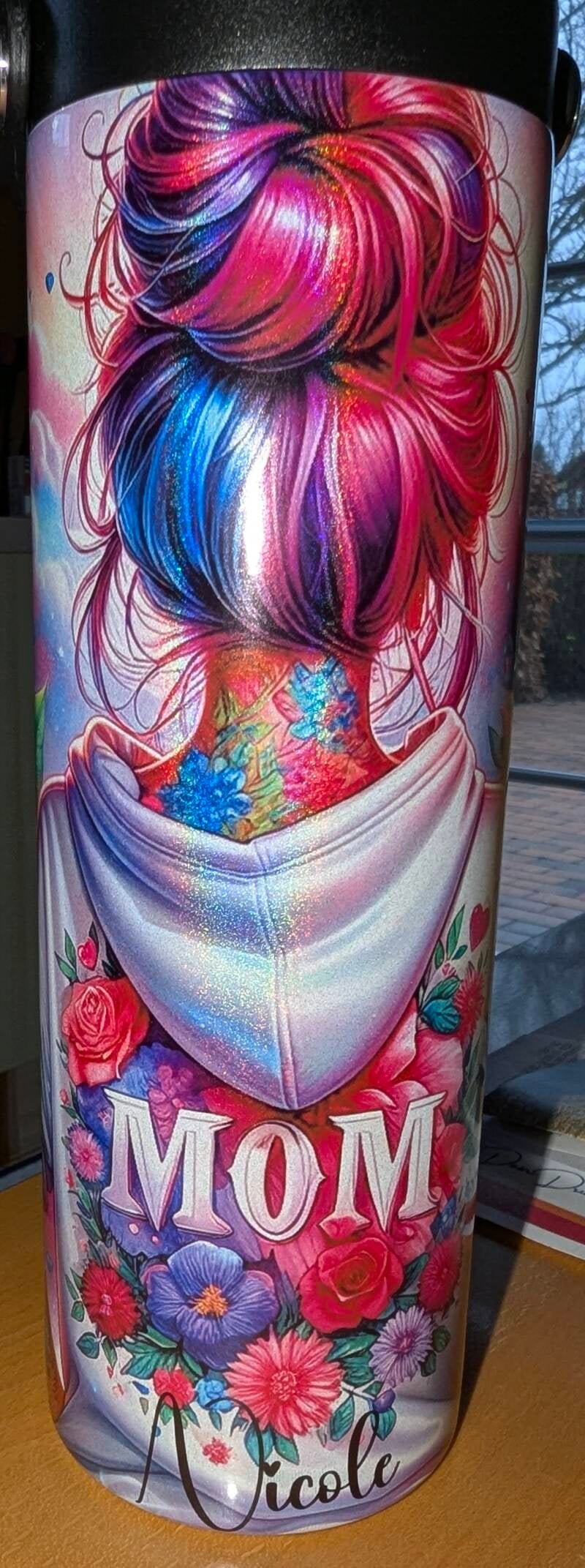 Personalisierter Thermobecher mit einer Frau mit Bunten Haaren, einem Dutt und einem weißen Blumenhoodie mit Mom. Personalisiert mit Namen Nicole.