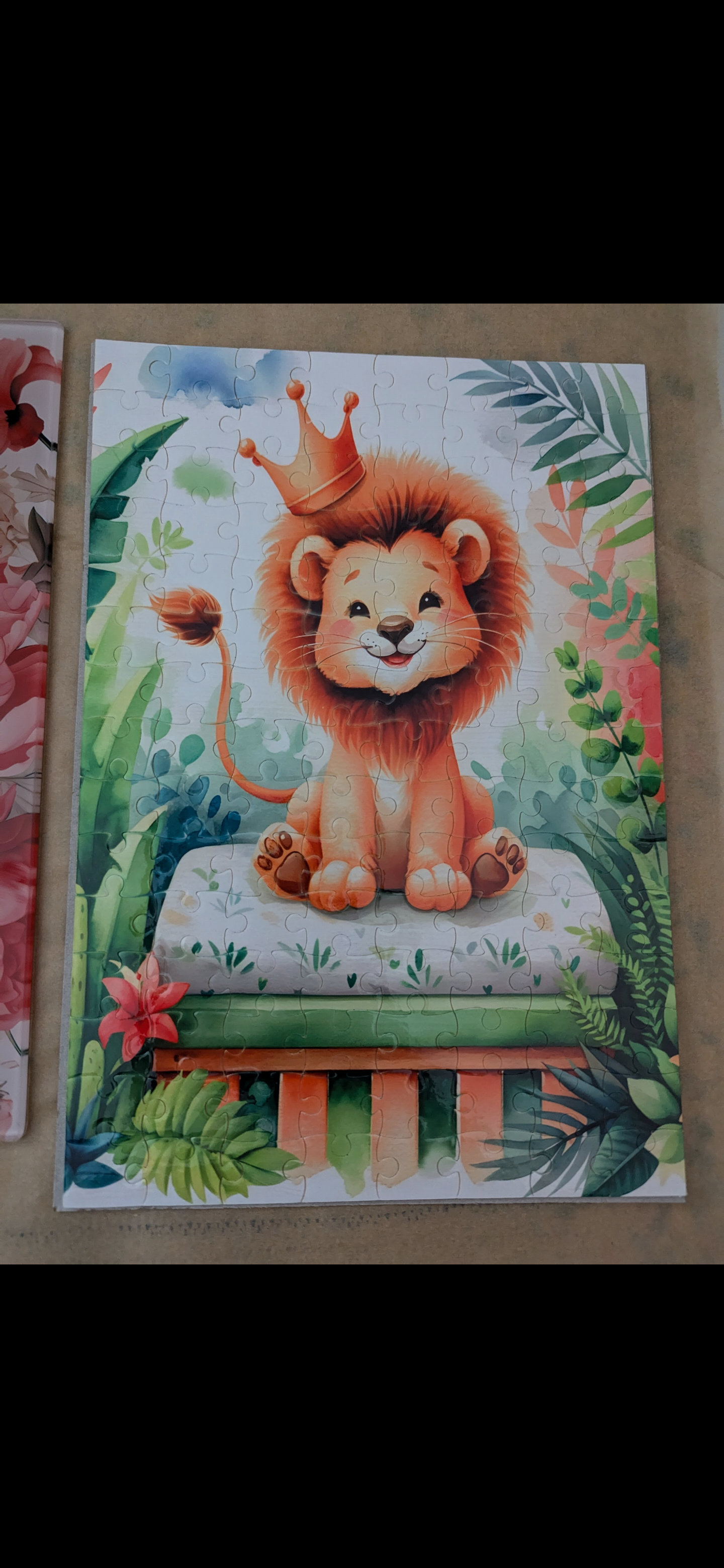 Sublimiertes Puzzle für einen Jungen mit einem Löwen und einer Krone, sitzend auf einem Tisch und im Hintergrund mit Palmen.