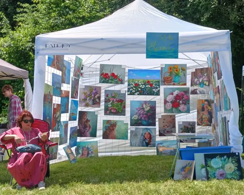 ElenaG seats before her tent at the art show.