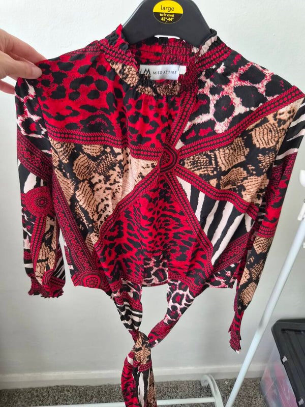 Red/black patterned cropped top with long sleeves. Size 8