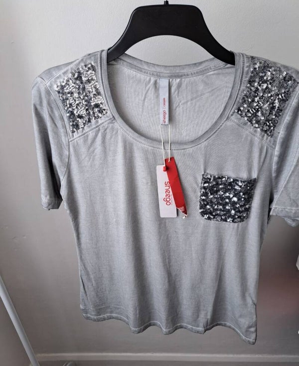 Grey distressed short sleeve top with sequins on the shoulders and pocket. Size 8-10