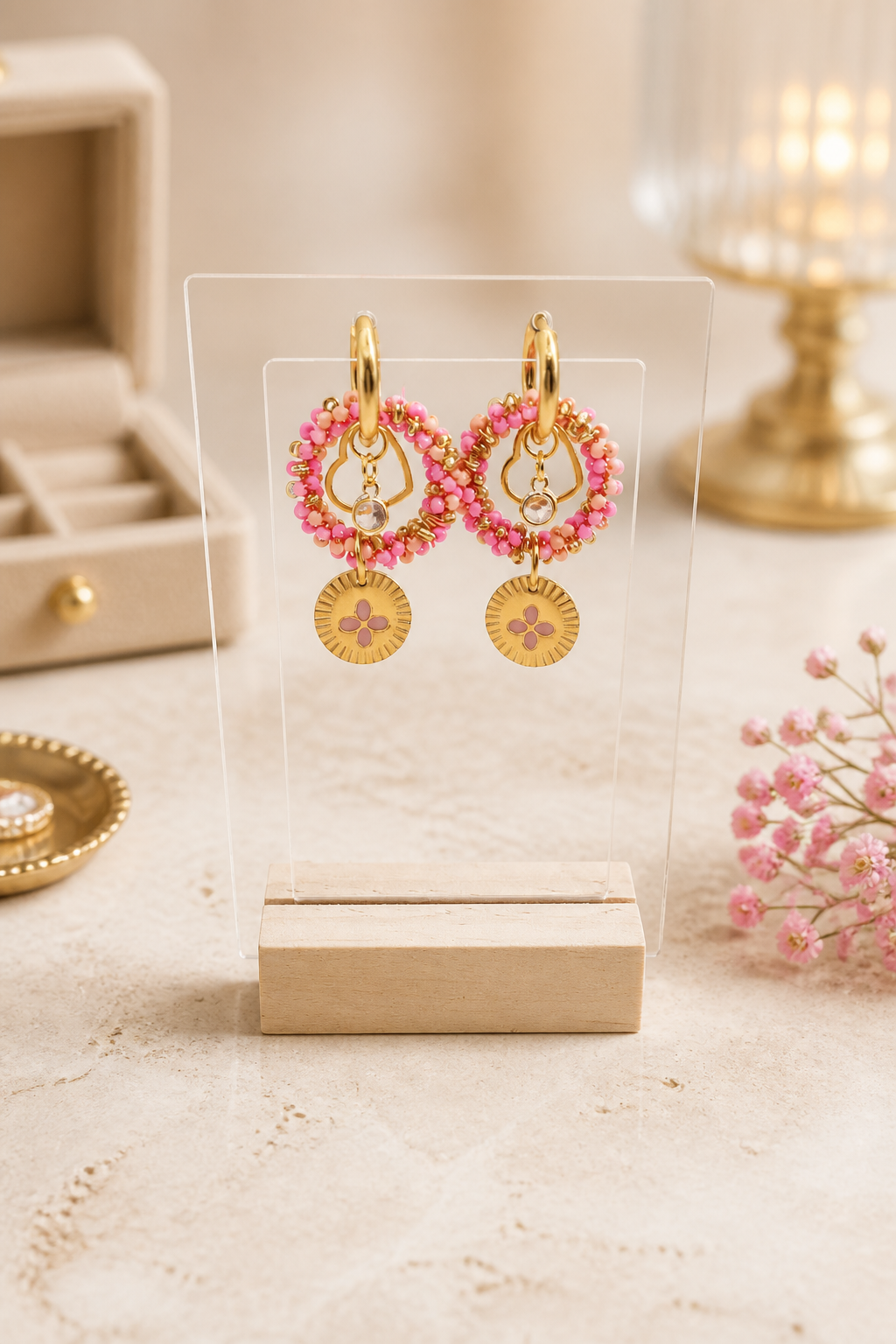 Goudkleurige oorbellen met roze/fuchsia kralen, klaver en hart bedel