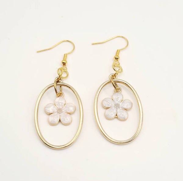 Goudkleurige oorbellen met statement hanger en witte bloem