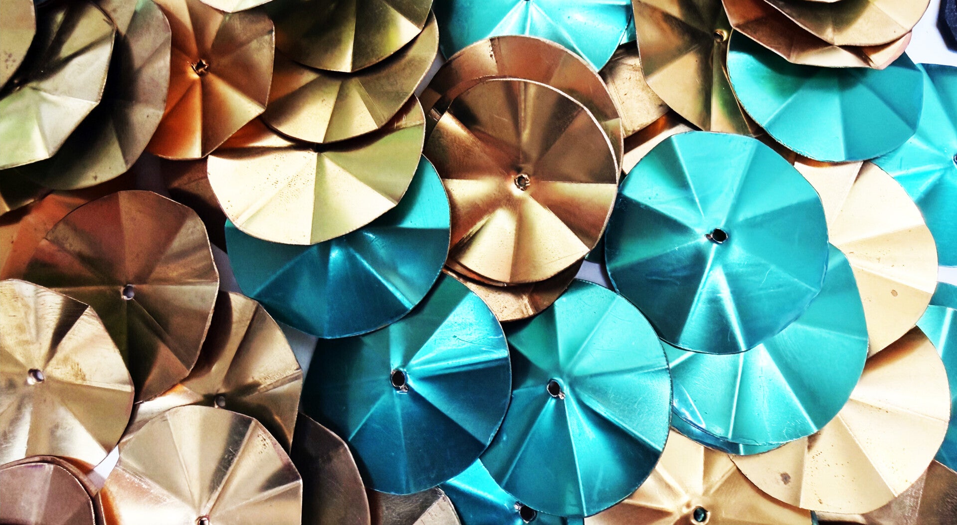 Cymbalettes dorées, cuivrées et turquoise destinées à la fabrication de pandeiros artisanaux pour la capoeira.