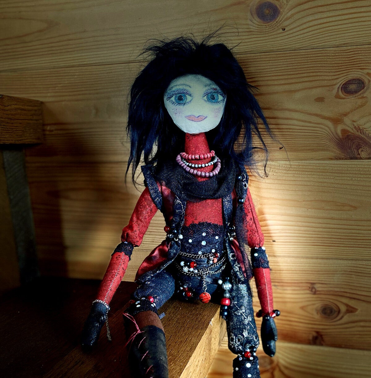 A gothic looking cloth art doll in red and black with beads and bling