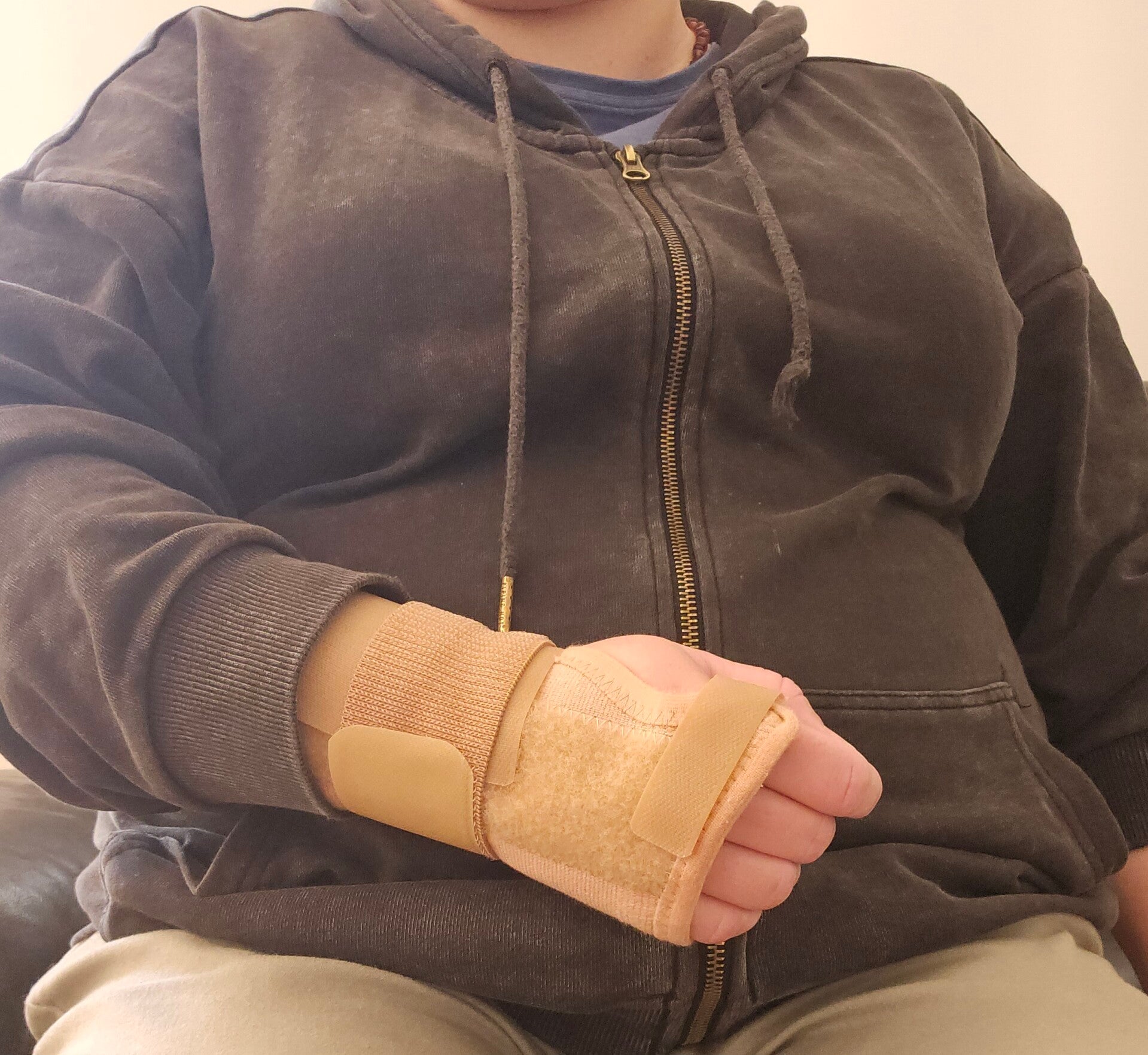 man in 40s looking concerned and wearing a sling on arm