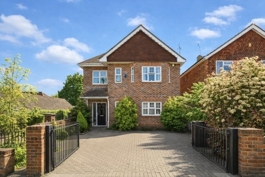 Front elevation of a detached brick house at 15 Penn Road with driveway and gated entrance