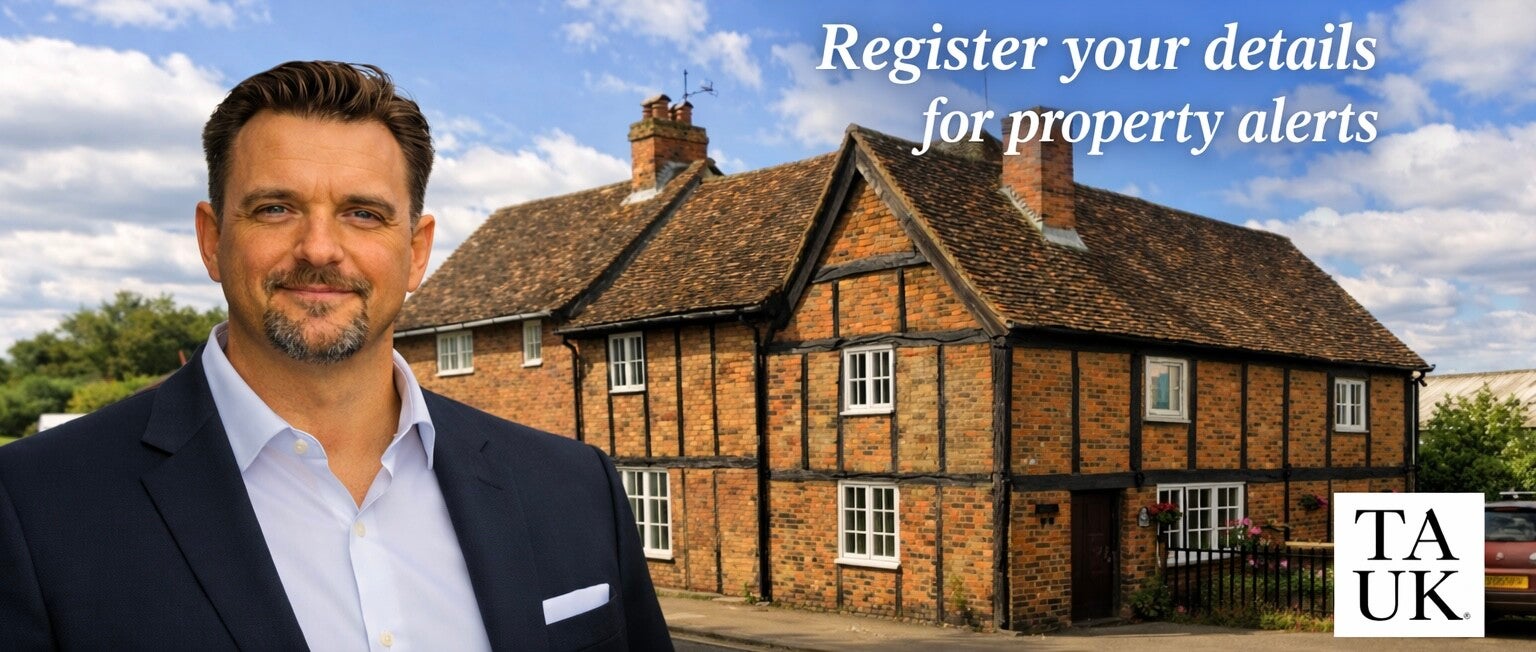 Neil Hughes standing in front of a traditional AL2 brick and timber cottage with white text reading Register your details for property alerts and TAUK logo.