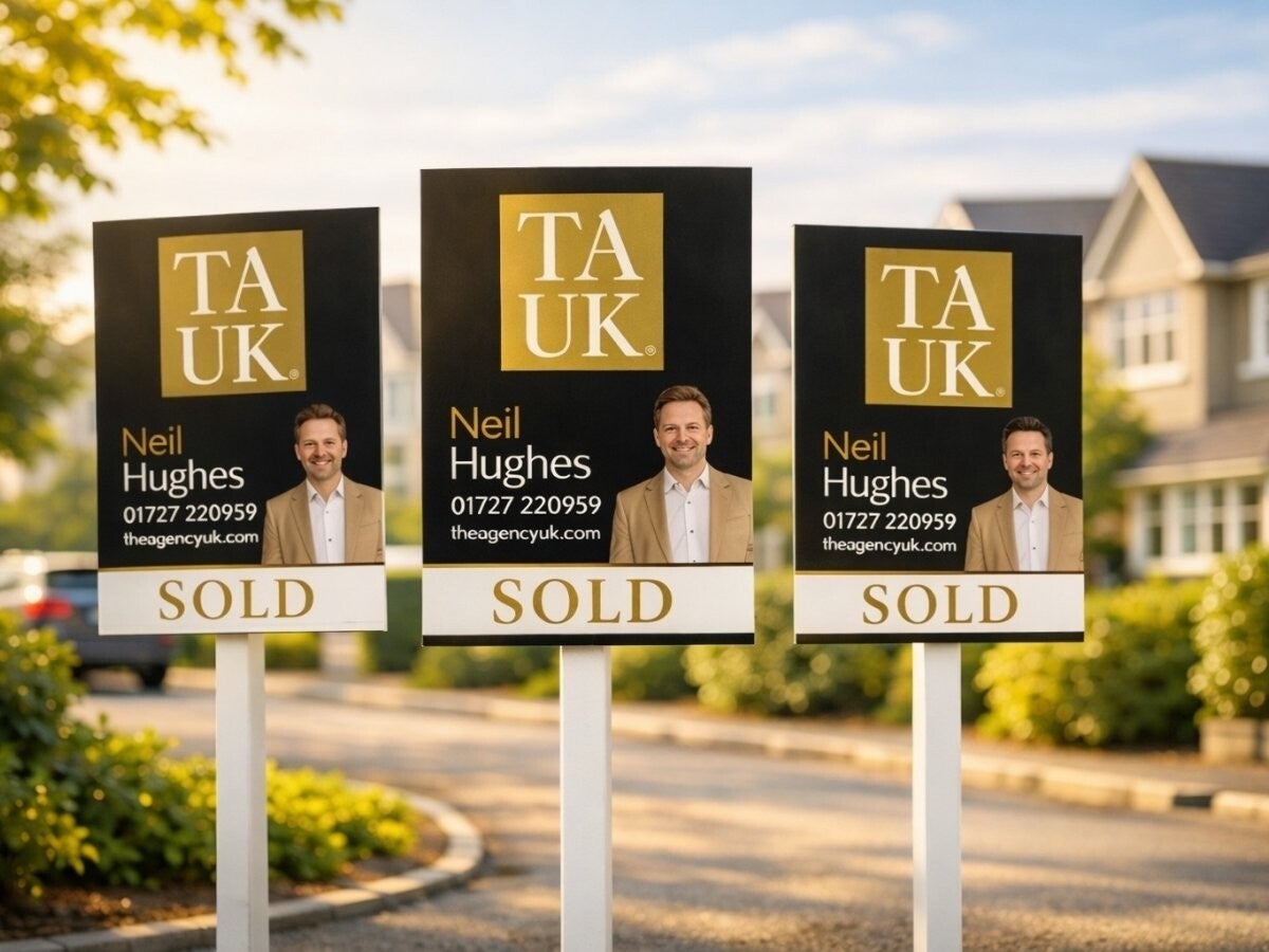 Three TAUK Neil Hughes SOLD boards in St Albans street, photographed in warm daylight showing recent property sales.