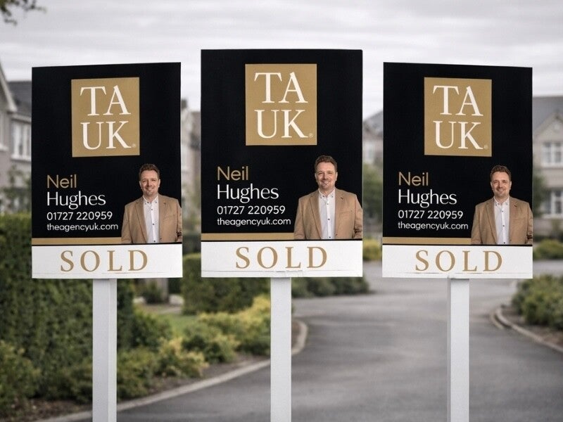 Three TAUK SOLD boards displayed in a premium St Albans neighborhood, featuring Neil Hughes branding and contact details.