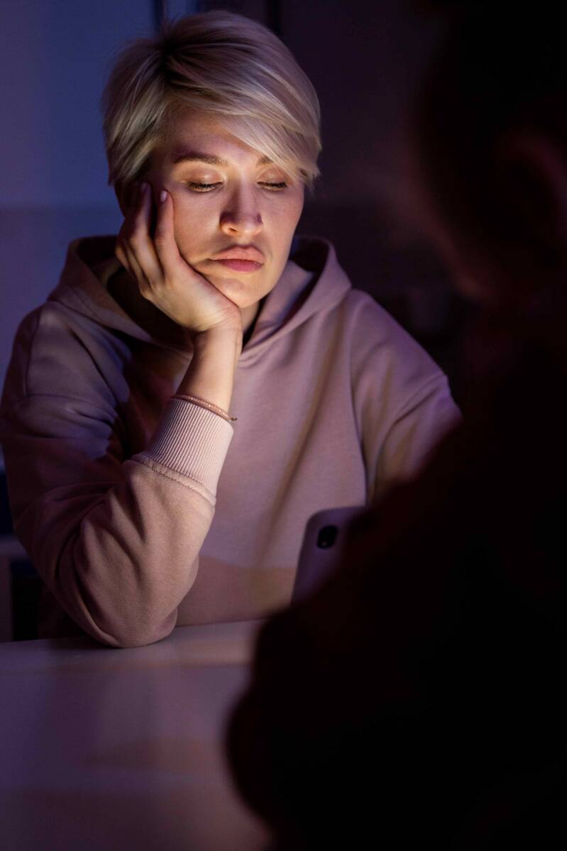 Junge Frau sitzt teilnahmslos vor ihrem Laptop. Sie leidet unter einer Borderline-Persönlichkeitsstörung und hat deshalb extreme Stummungsschwankungen.