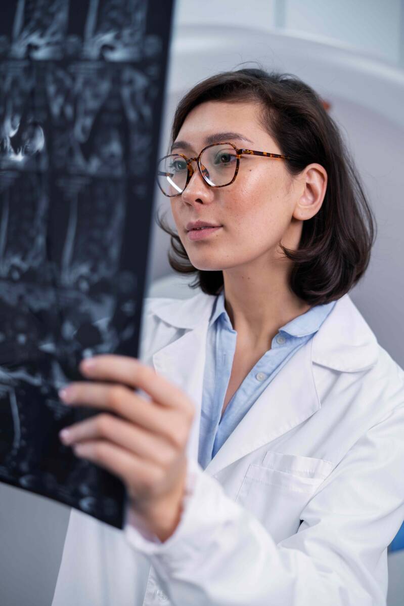 Arztin schaut sich ein Röntgenbild mit einem Knochenbruch an.