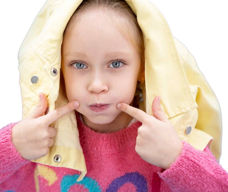Kleines Mädchen bläst die Backen auf , weil sie zeigen möchte wie es aussieht, wenn man Mumps hat.