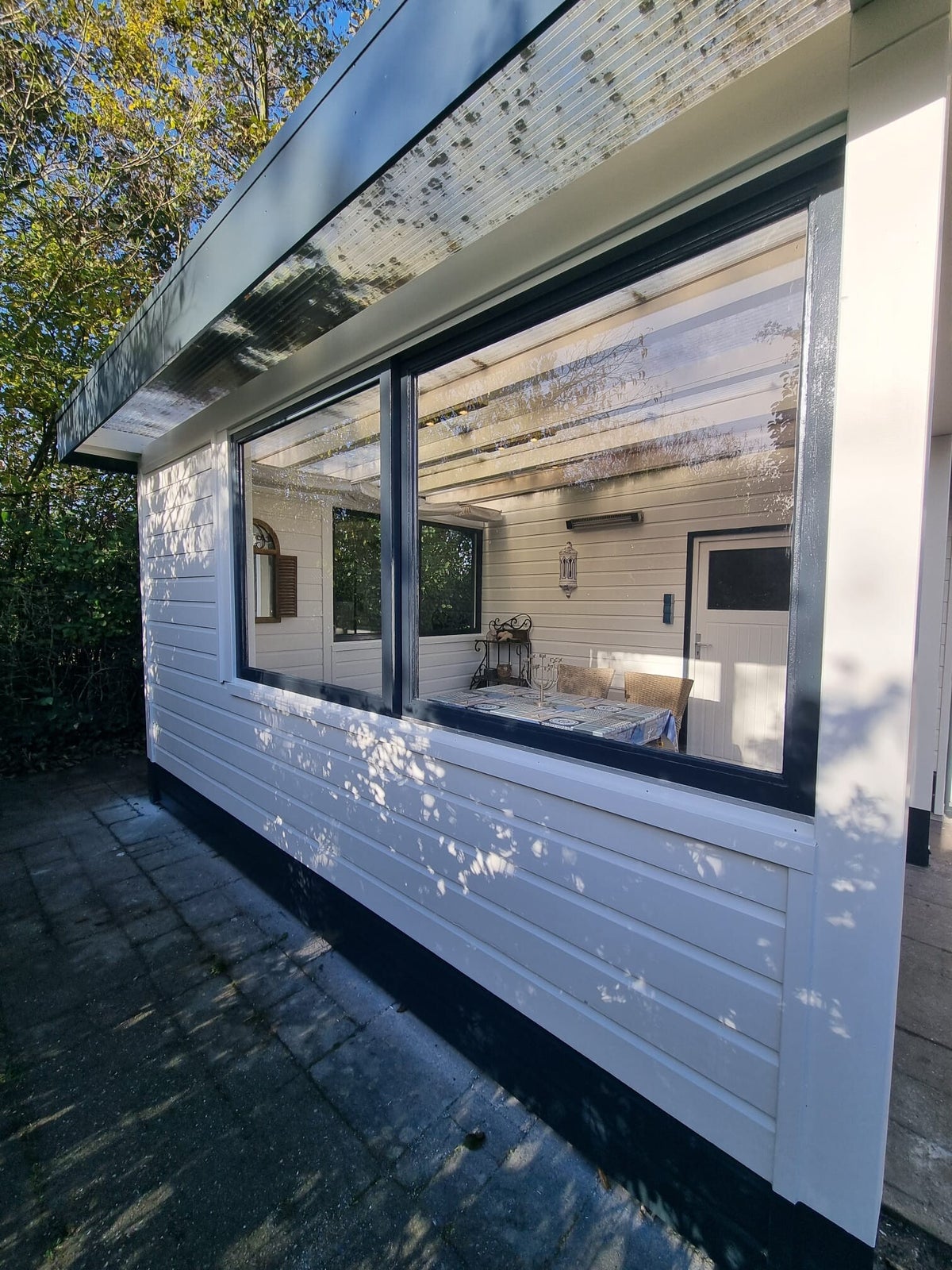 Bungalow met houten rabat, strak wit geschilderd met antraciet kozijnen