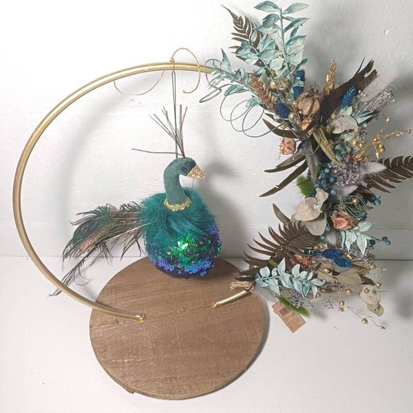 Petrol blauwe krans met droogbloemen en speelse pauw