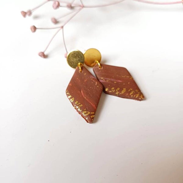 Goudkleurige stekers met bruine klei hanger