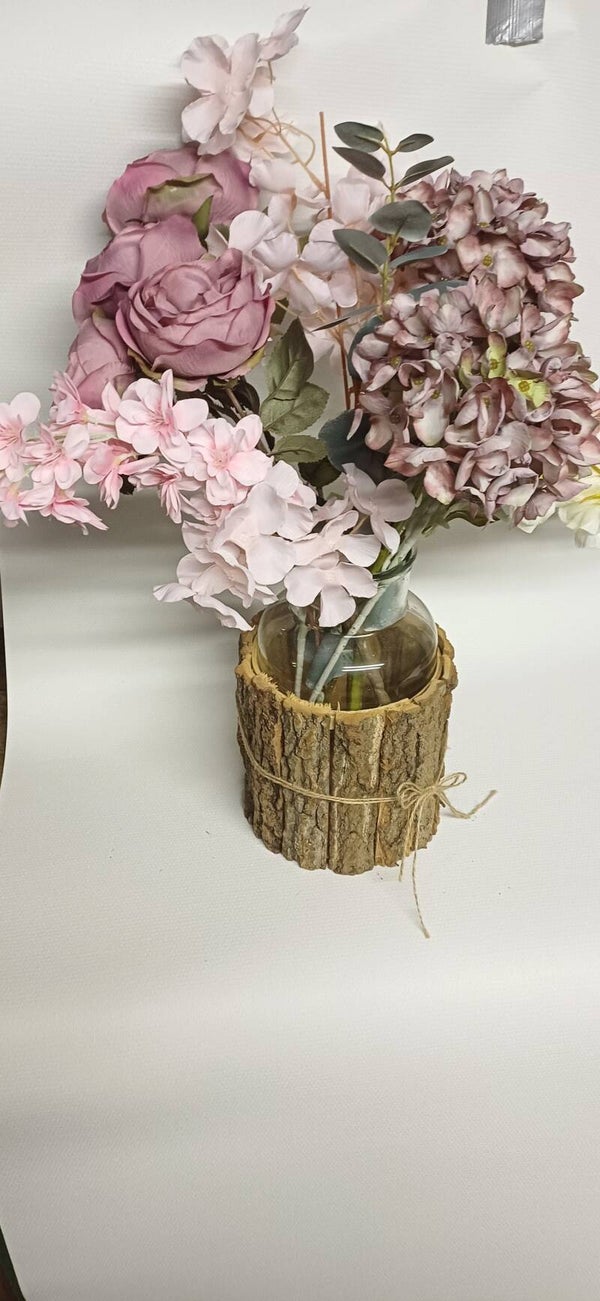 Gevulde vaas met zijdebloemen in oud roze tinten.