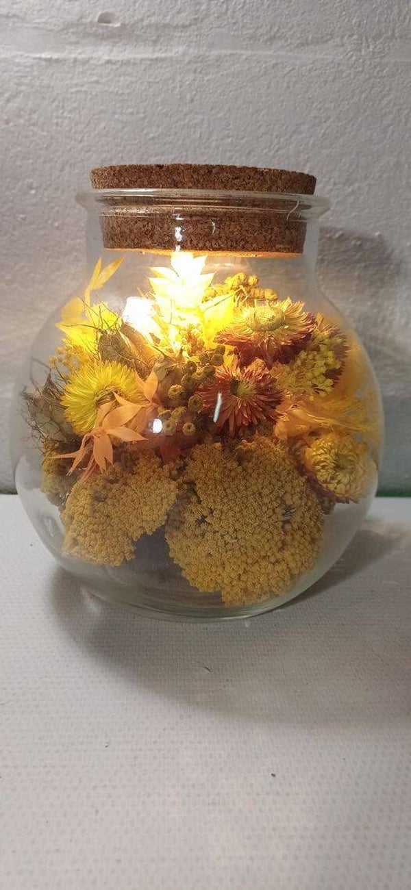 Glazen vaas met lichtjes en droogbloemen