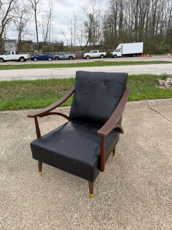 Mid-Century Modern armchair featuring wood armrests and black upholstery