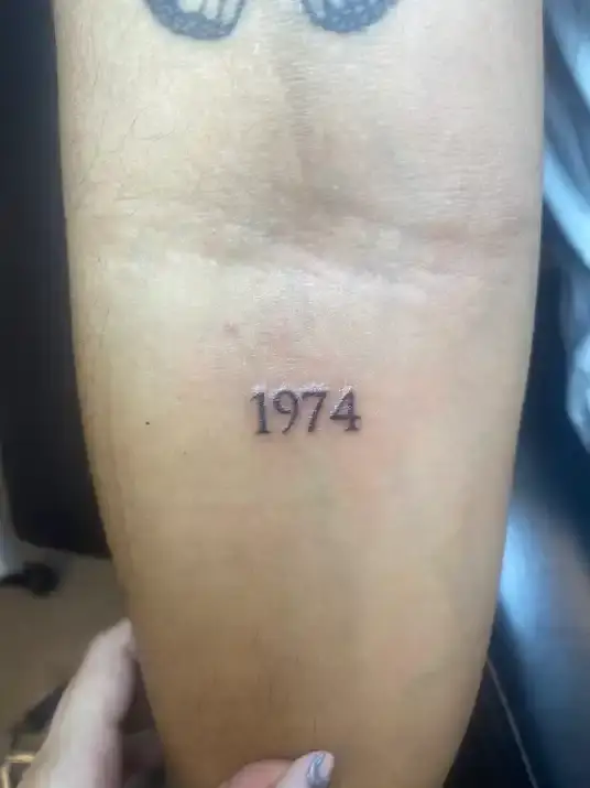 Fineline geboortejaar tattoo op onderarm. Gezet bij Studioostveen | Tattooshop Almere Poort
