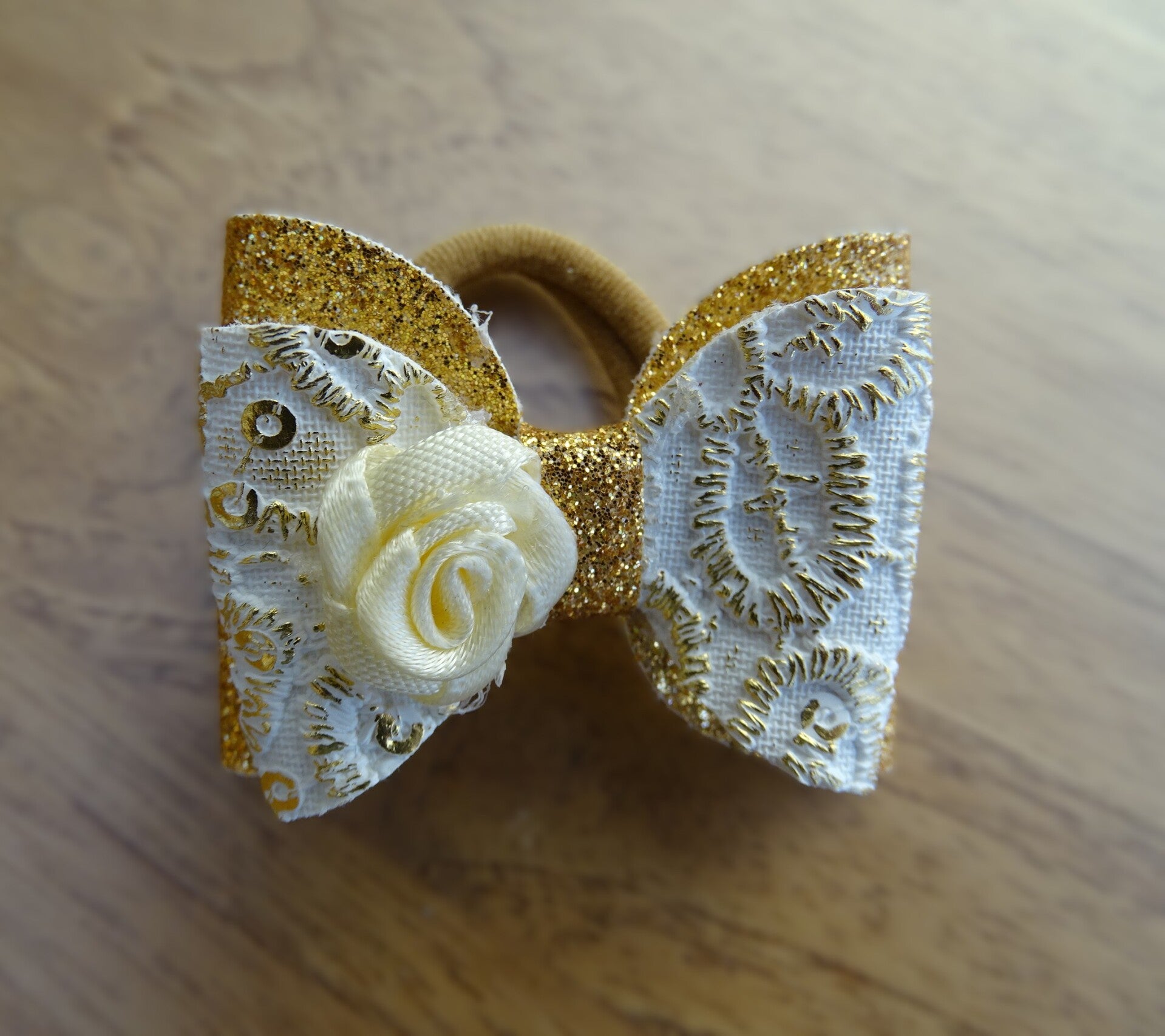 Strik elastiek goud/wit roosje