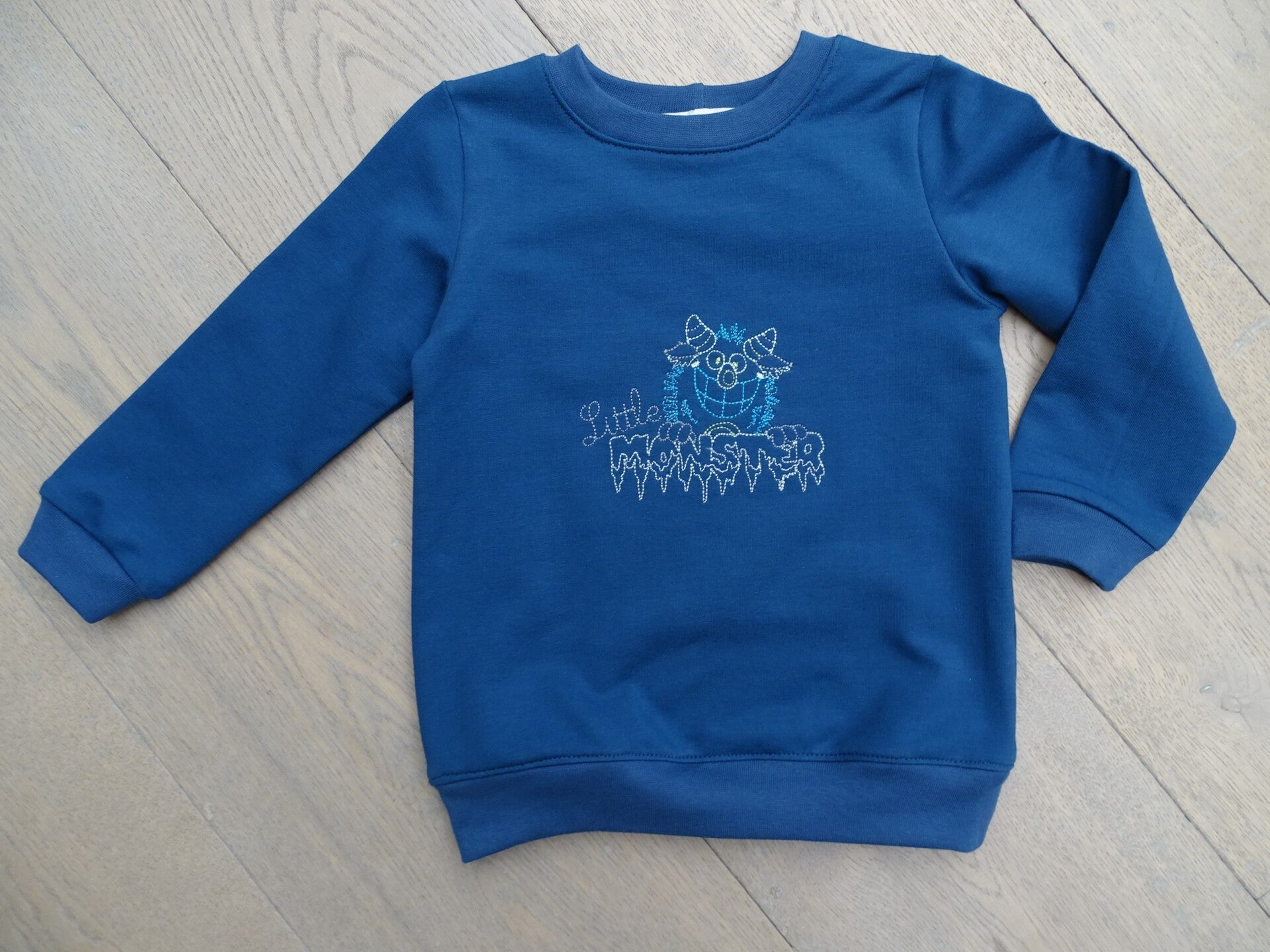 sweater uni blauw borduur little monster