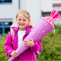 Glückliches Mädchen mit Schultüte am ersten Schultag – ein besonderer Moment aus Emmas Tagebuch.