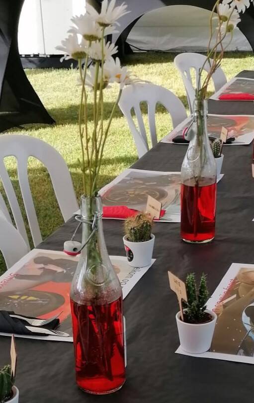 Glazen beugelflessen van 750 ml gevuld met witte bloemen en gekleurd water