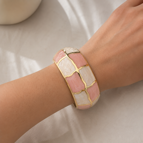 Goudkleurige cuff armband met roze en witte parelmoerlook details