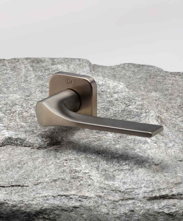 Maniglia per porta design moderno con finitura bronzo satinato, stile elegante e contemporaneo su superficie in pietra