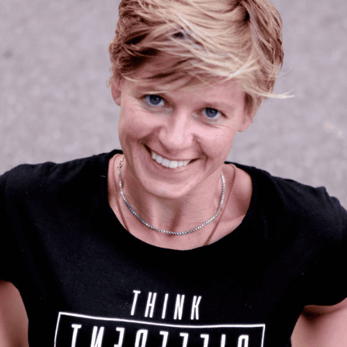 Portretfoto Judith van der Steeg,  glimlachend in de camera, met zwart "think different " T-shirt 